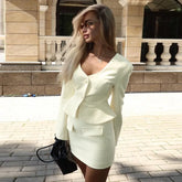 Woman in a light green blazer dress standing outdoors on a sunny day.